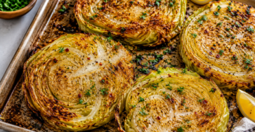 Cabbage Steaks final dish with crispy roasted cabbage slices, golden edges, parsley, lemon wedges, and savory spices